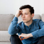 muskarac-sedi-na-podu-zamisljen