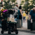 kolica-sa-cvecem-covek-sedi