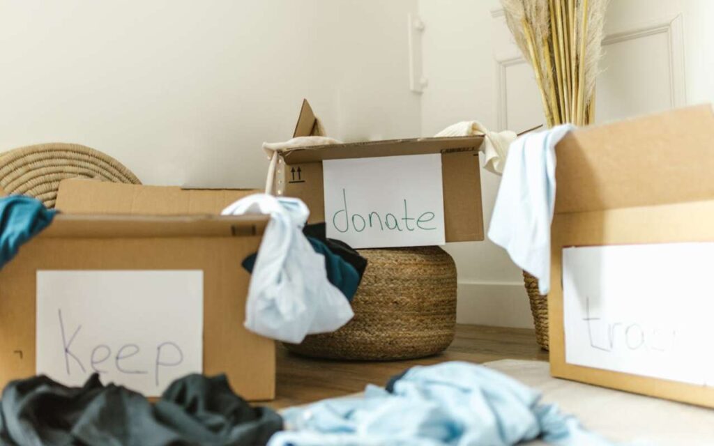 Tri kutije sa odećom na kojima piše donate i keep i trash
