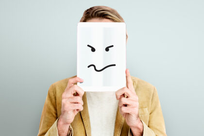 muskarac-drzi-preko-lica-emotikon-negativnog-raspolozenja