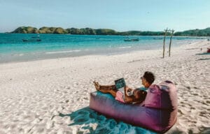 Muškarac na plaži sa laptopom