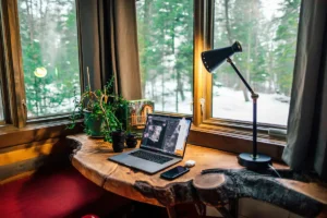 Laptop na radnom stolu pored prozora