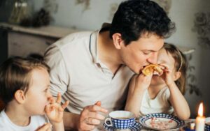 Čovek pije čaj sa decom.