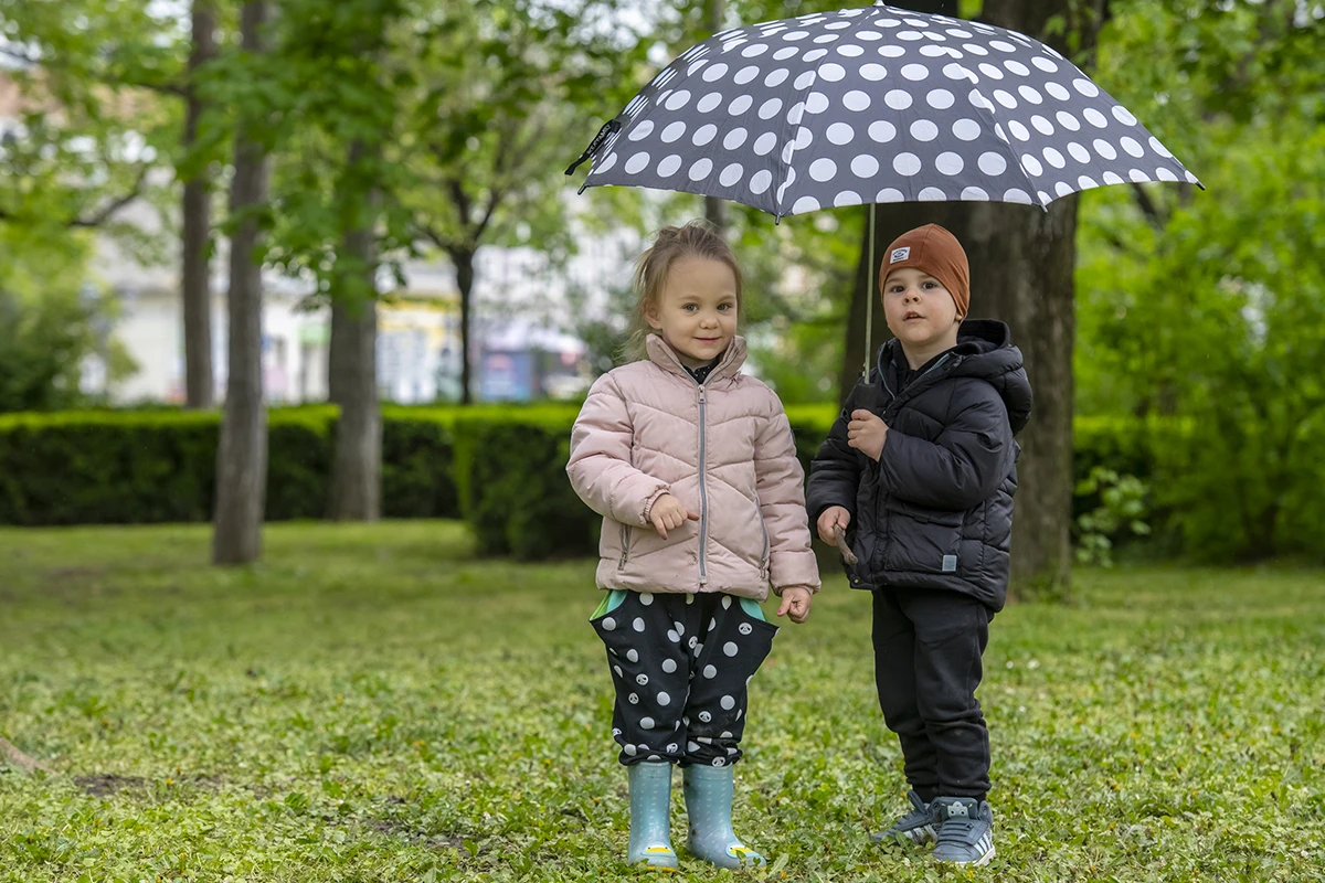 Dečak i devojčica pod kišobranom