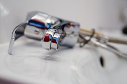 Hromirana slavina leži na belom umivaoniku