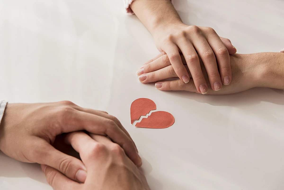 Krupni plan ruku sa slomljenim srcem