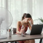 Devojak ispred laptopa i ventilatora