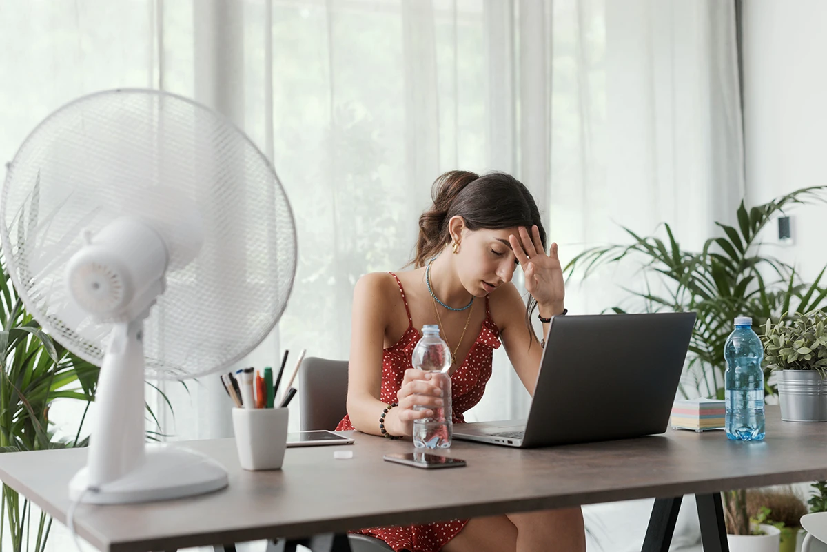 Devojak ispred laptopa i ventilatora