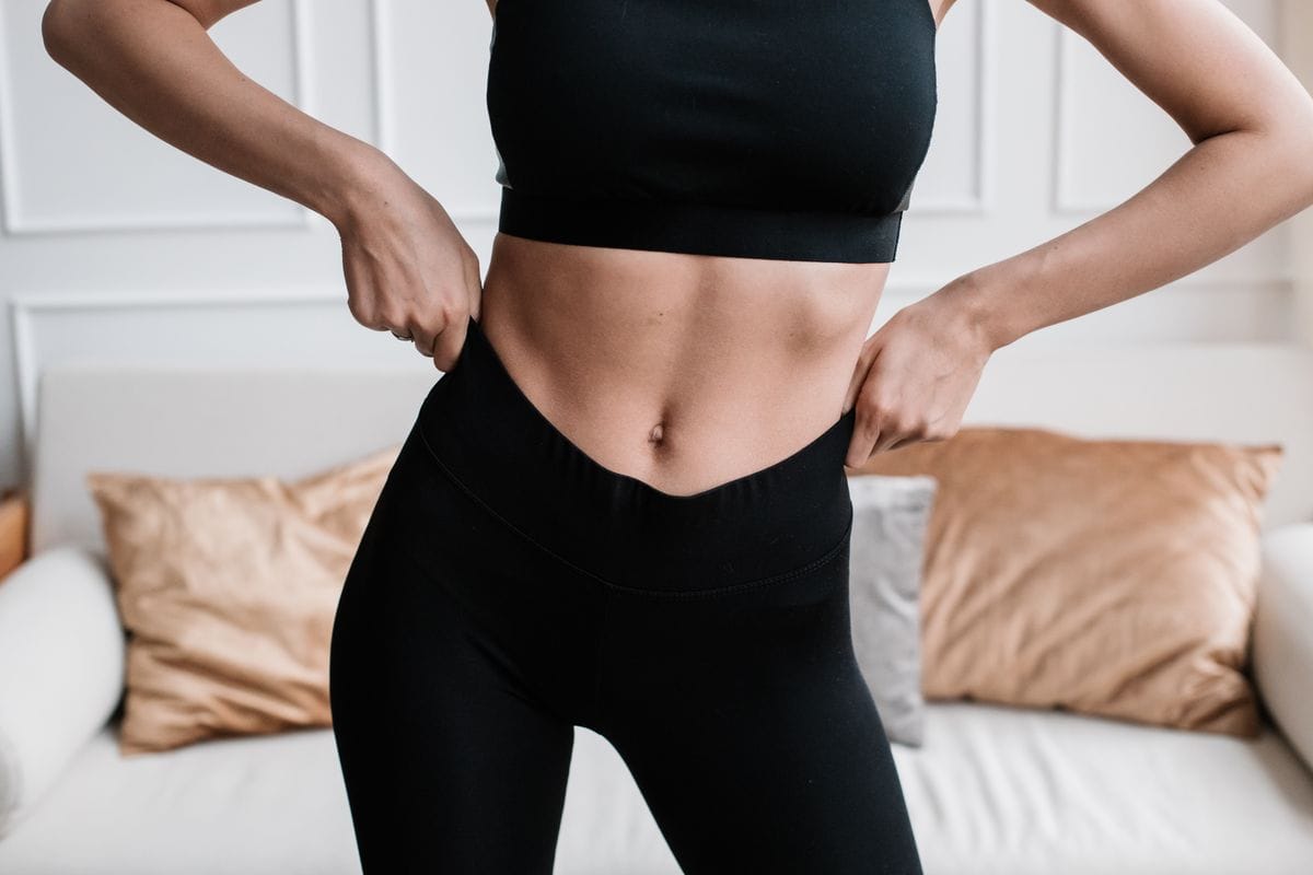 • N2 portal Žena u sportskoj odeći namešta pantalone u modernom i elegantno uređenom dnevnom boravku