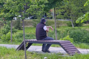 čovek sedi na klupi