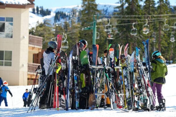 Grupa ljudi okupljena oko ski opreme na snežnom ski centru.